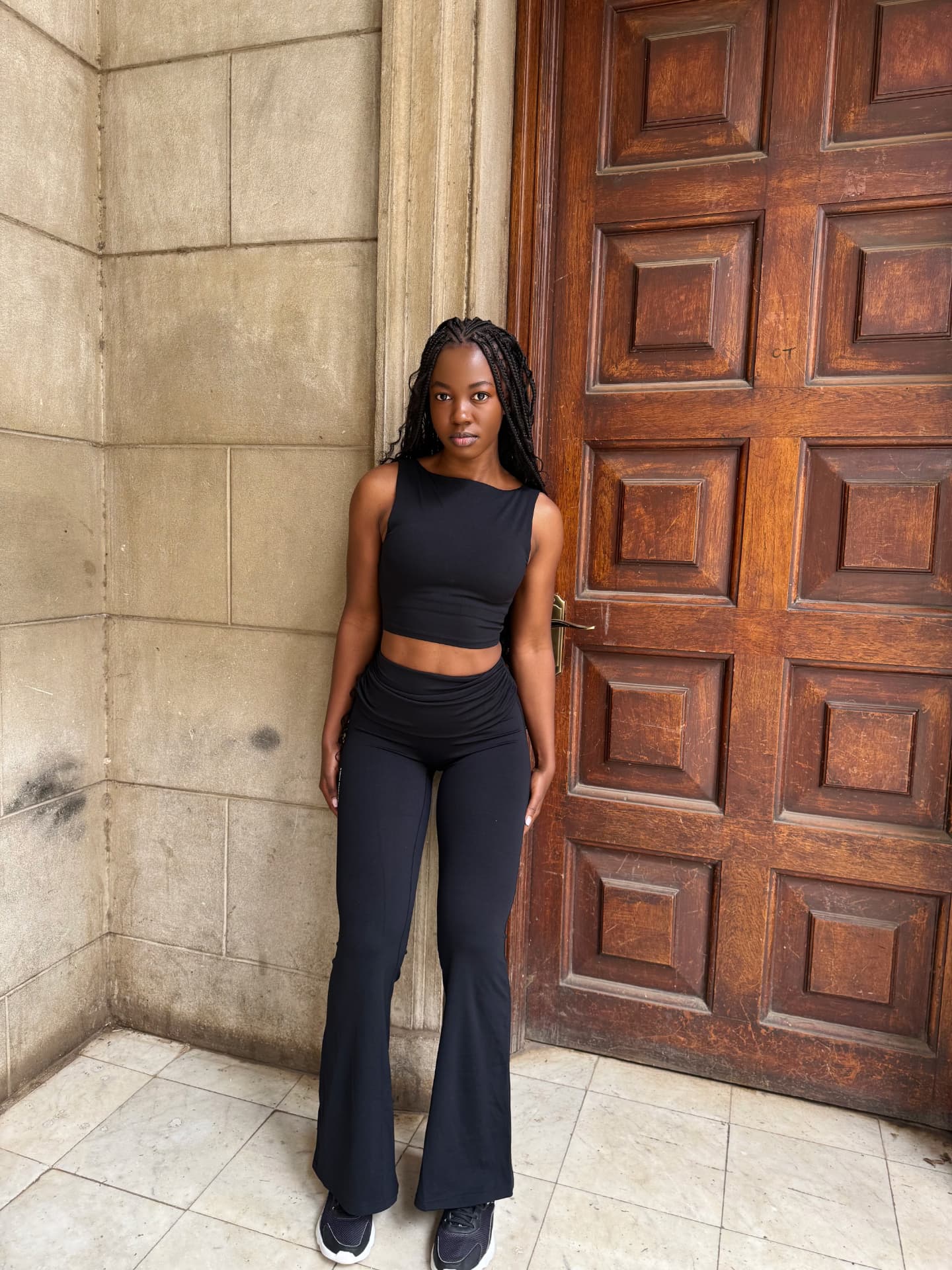 Woman wearing a black sleeveless top and flared trousers